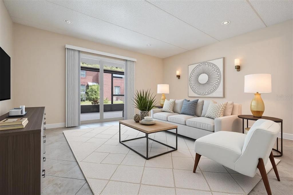 A kitchen features white cabinets, stainless steel appliances, and dark countertops with a tile floor — 8565 12TH WAY N UNIT A, ST PETERSBURG, FL
