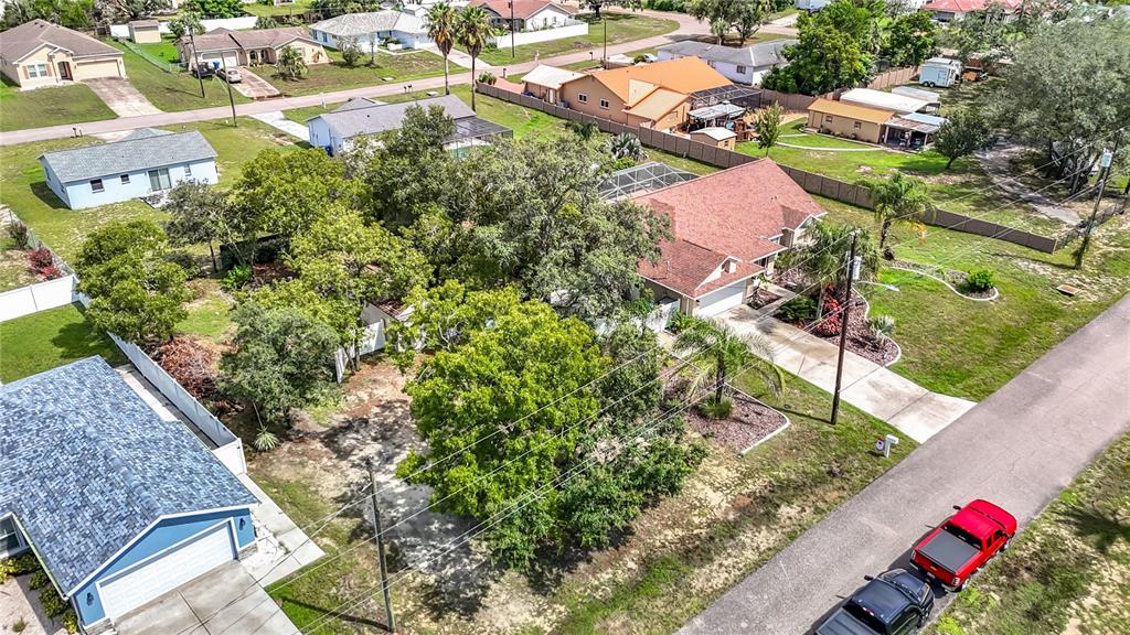 An aerial view shows a residential neighborhood with several houses, driveways, and mature trees — 1388 HASTINGS ROAD, SPRING HILL, FL