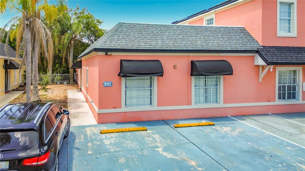 A pink exterior building with two windows, black awnings, and a parking lot in front — 1008 UNIVERSAL REST PLACE, KISSIMMEE, FL