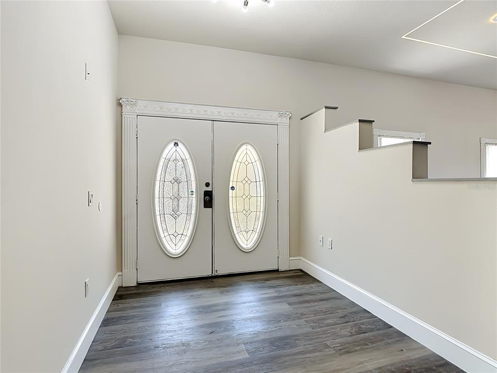 An entryway features double doors with oval glass inserts and wood-look flooring — 1008 UNIVERSAL REST PLACE, KISSIMMEE, FL