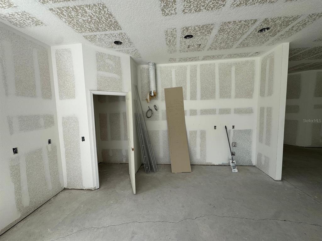 An unfinished room features drywall with taped seams, a concrete floor, and recessed lighting — 6701 OLD MELBOURNE HIGHWAY UNIT A, ST CLOUD, FL