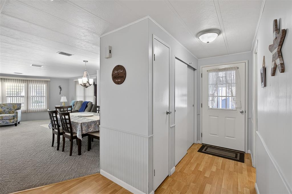 An entryway with wood flooring leads into a carpeted dining area and living room — 652 LA SALA, NORTH PORT, FL
