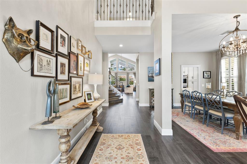 A foyer with a gallery wall and console table leads to a dining room — 304 9TH AVENUE E, PALMETTO, FL