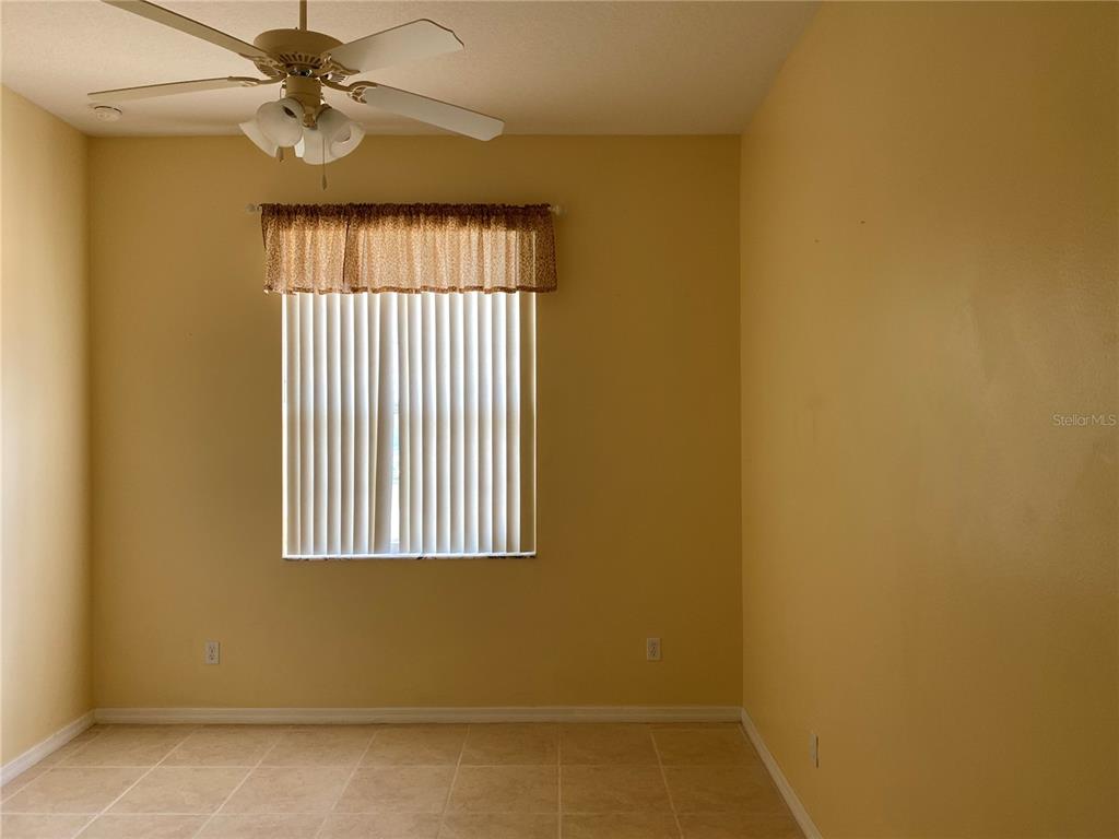 A room with yellow walls, tile flooring, a ceiling fan, and a window with blinds — 12934 COLONNADE CIRCLE, CLERMONT, FL