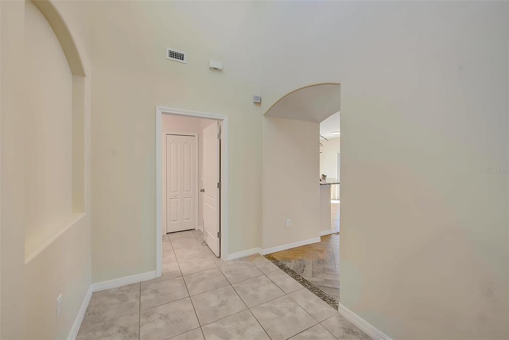 A tiled entryway leads to a hallway with a doorway and an arched opening — 1902 HAWKS VIEW DRIVE, RUSKIN, FL