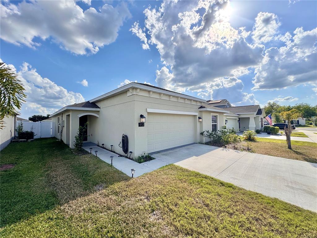 A single-story house with a beige stucco exterior, a two-car garage, and a concrete driveway — 913 WASHINGTON STREET, BARTOW, FL
