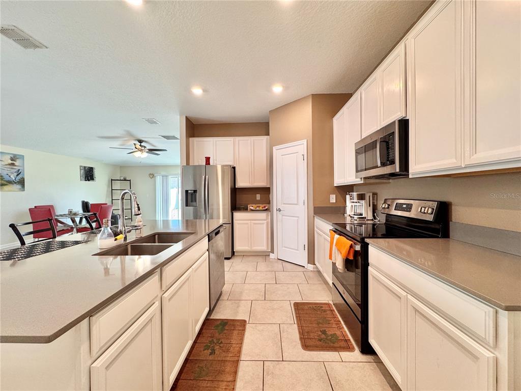 A kitchen features white cabinets, stainless steel appliances, and a large island with a sink — 913 WASHINGTON STREET, BARTOW, FL