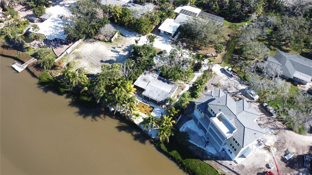 An aerial view shows waterfront properties, including a large multi-story house under construction — 8534 HERON LAGOON CIRCLE, SARASOTA, FL