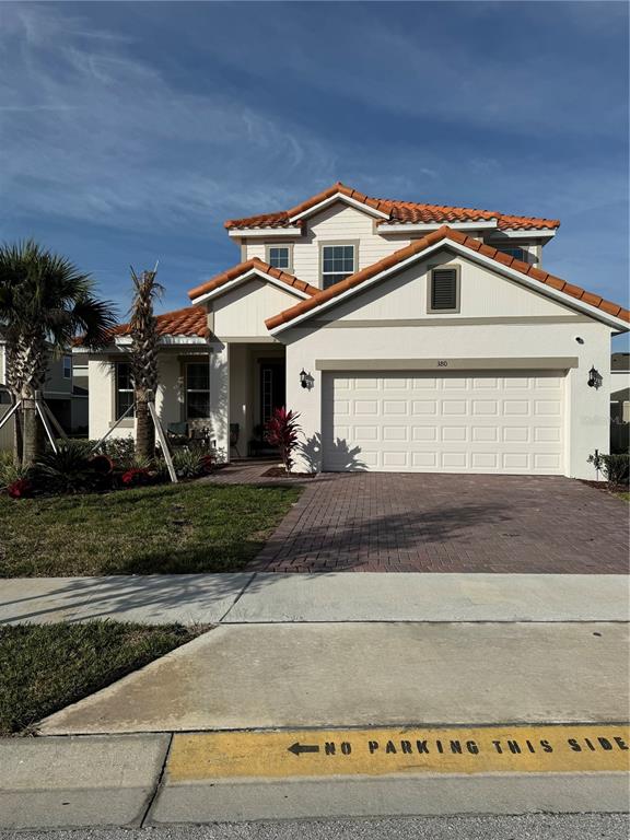 A two-story house with a white exterior, orange tile roof, and a paved driveway — 380 CABELLO DRIVE, DAVENPORT, FL