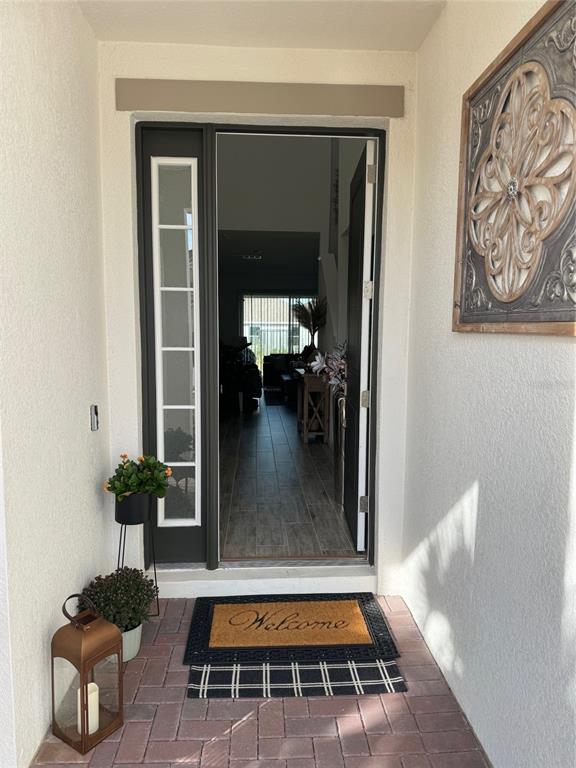 A front entryway features a dark door with a sidelight, a welcome mat, and a lantern — 380 CABELLO DRIVE, DAVENPORT, FL