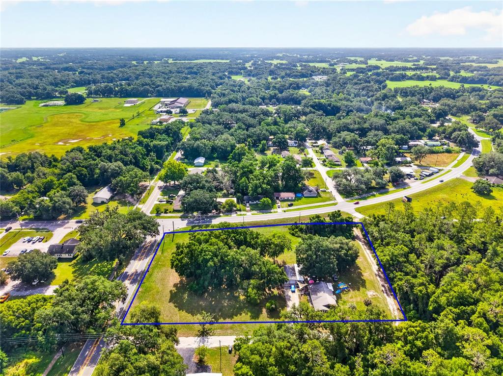 An aerial view shows a rectangular property lot with a house and trees — 309 S CENTER STREET, BUSHNELL, FL
