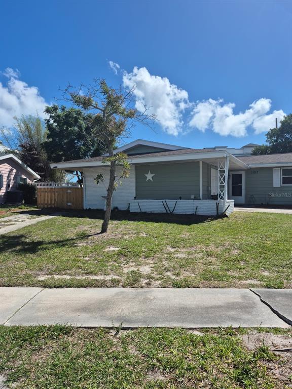 A single-story house with a white brick facade, green siding, and a star decoration — 1107 CABLE LANE, PALM BAY, FL