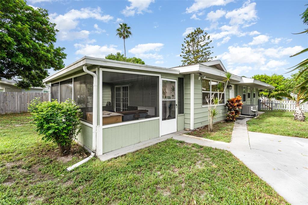 A light green house with a screened-in porch and a concrete walkway — 1107 CABLE LANE, PALM BAY, FL