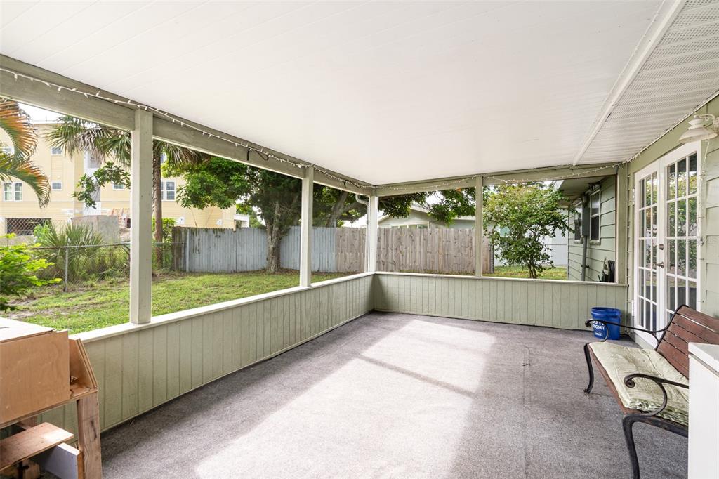 A covered patio with light green walls, a gray carpeted floor, and a view of the yard — 1107 CABLE LANE, PALM BAY, FL