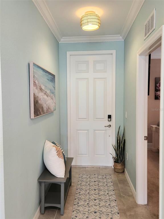 A light blue entryway features a white door, a gray bench, and a patterned rug — 18114 GAWTHROP DRIVE UNIT 103, BRADENTON, FL