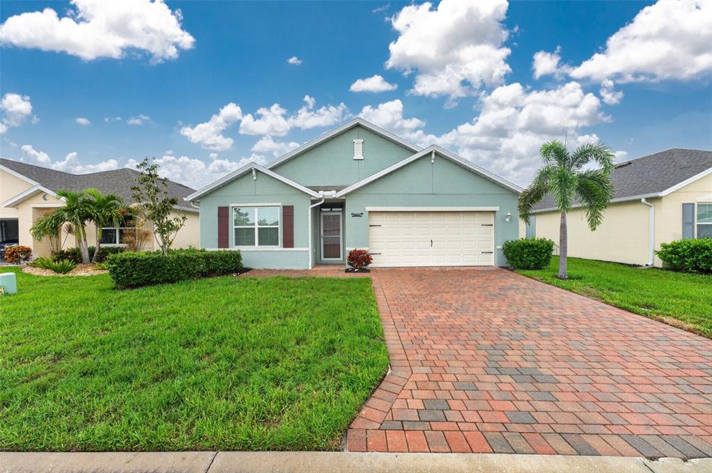 A single-story house with a light green exterior, brick paver driveway, and a two-car garage — 4107 MANATEE LANE, PUNTA GORDA, FL