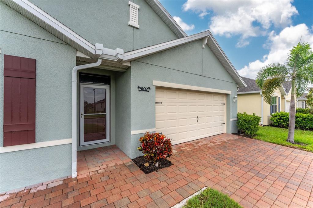 A light green house exterior features a brick driveway, a garage, and a front entrance — 4107 MANATEE LANE, PUNTA GORDA, FL