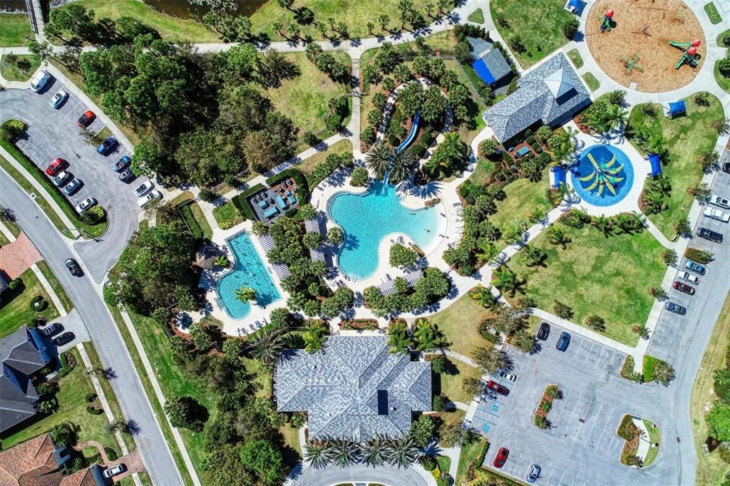 An aerial view shows a community pool complex with a waterslide, playground, and parking lots — 1314 STILL RIVER DRIVE, VENICE, FL