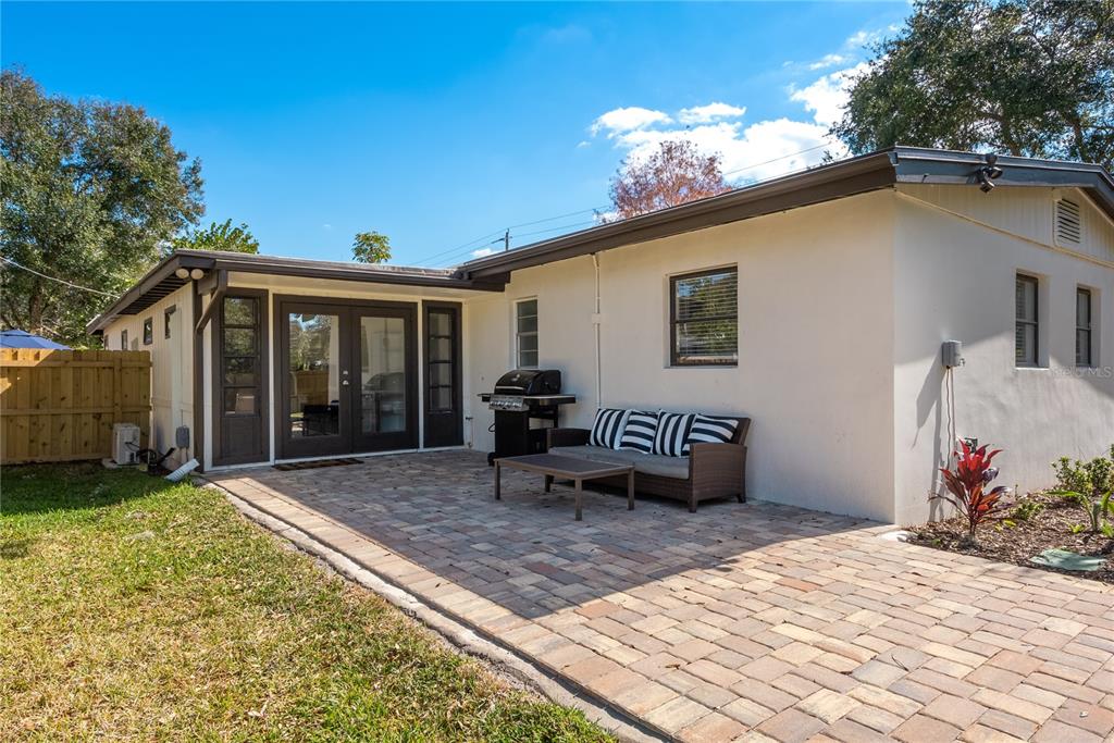 A backyard patio features a paver floor, a small sofa, and a grill — 2311 WALDEMERE STREET UNIT A, SARASOTA, FL