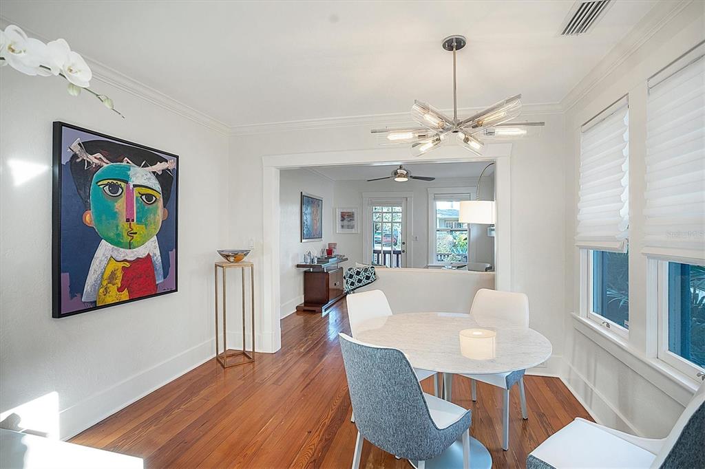 A dining room with hardwood floors, a round marble table, and a modern chandelier — 1716 OAK STREET, SARASOTA, FL