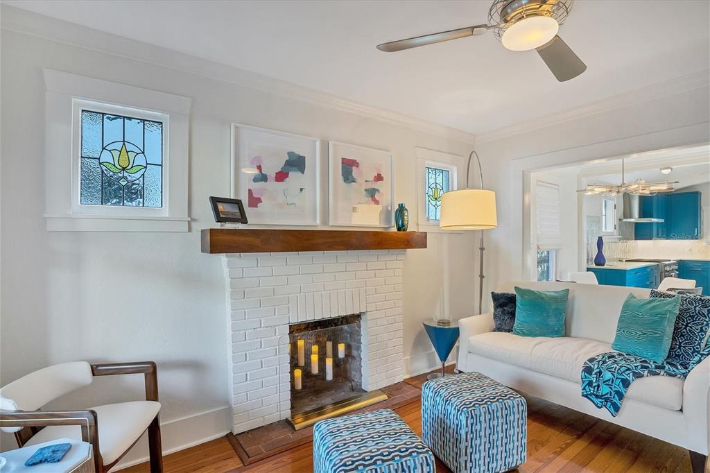 A living room features a white brick fireplace, stained glass windows, and blue patterned furniture — 1716 OAK STREET, SARASOTA, FL