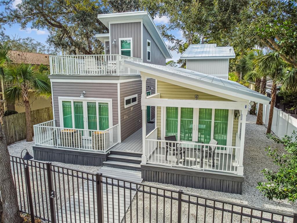 A two-story house with gray and yellow siding, multiple decks, and a metal roof — 1523 BAYSHORE BOULEVARD UNIT 3, DUNEDIN, FL
