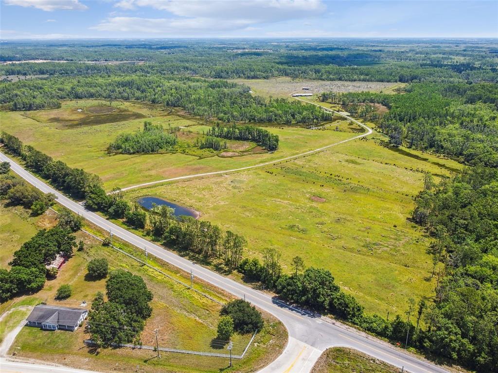 An aerial view shows a rural landscape with a road, a house, and open fields — 0 ST RD 557, LAKE ALFRED, FL
