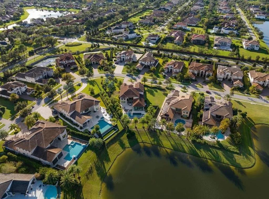 An aerial view of a suburban neighborhood featuring large houses with swimming pools near water — 4302 ISABELLA CIR, WINDERMERE, FL
