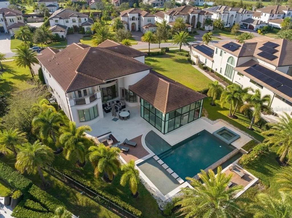 Aerial view of a large house with a swimming pool, glass-enclosed room, and palm trees — 4302 ISABELLA CIR, WINDERMERE, FL