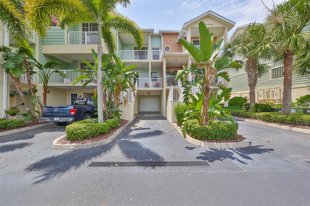 A multi-story residential building with a driveway, garage, and tropical landscaping in front — 3226 MANGROVE POINT DRIVE, RUSKIN, FL