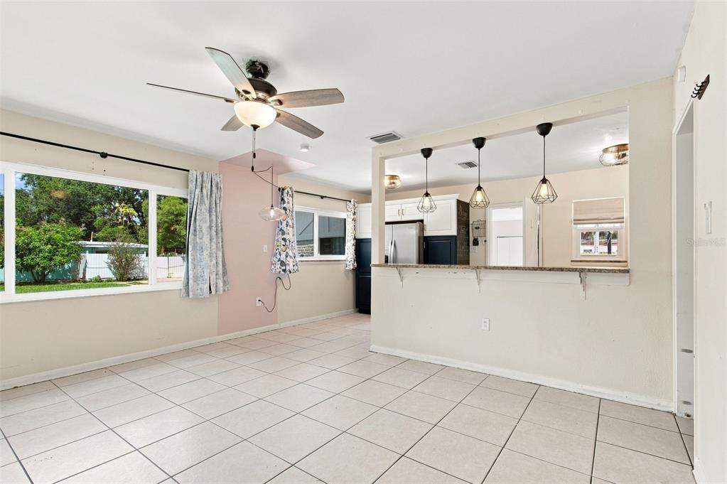 A dining area with tile floors, a ceiling fan, and a pass-through to the kitchen — 2002 E HAMILTON AVENUE, TAMPA, FL
