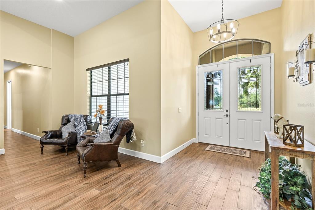 An entryway features wood-look tile flooring, two leather armchairs, and a double front door — 5319 W TRAPNELL ROAD, DOVER, FL
