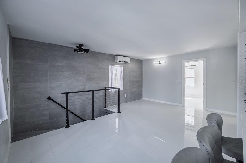 A modern kitchen features white cabinets, stainless steel appliances, a window, and a ceiling fan — 1427 ASHER LANE, ORLANDO, FL