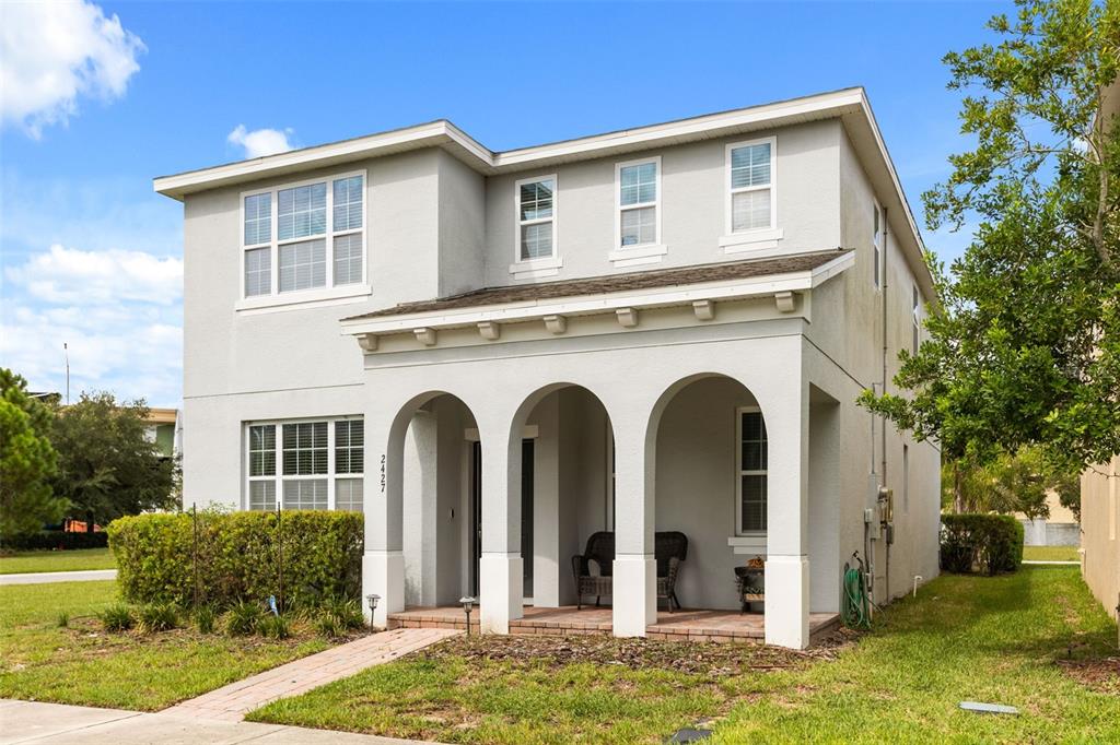 A two-story house with a light gray stucco exterior and a three-arched front porch — 2427 LINER AVENUE, APOPKA, FL
