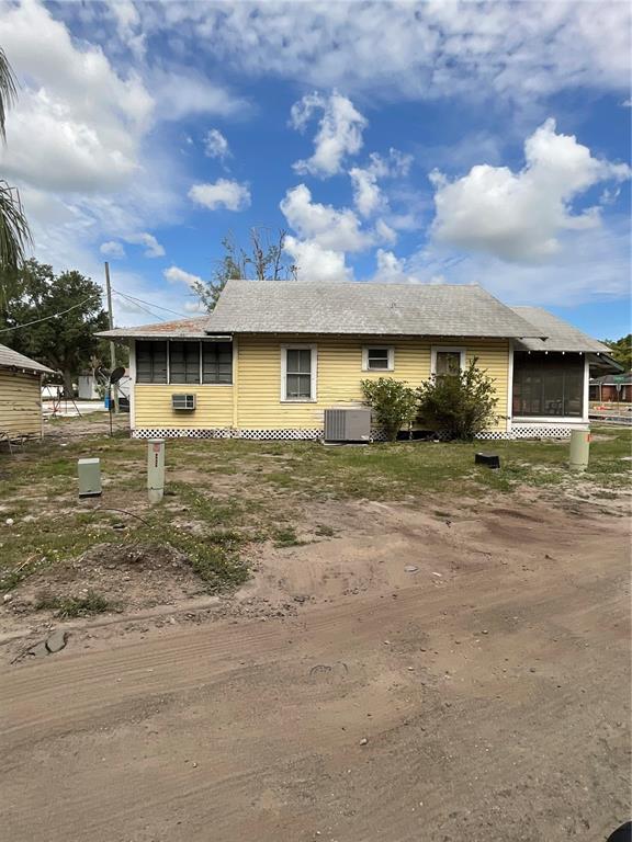 A yellow, single-story house with a shingled roof sits on a dirt lot — 628 E MAGNOLIA STREET, ARCADIA, FL