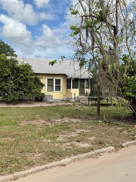 A yellow, single-story house with a screened porch sits behind a large, mossy tree — 628 E MAGNOLIA STREET, ARCADIA, FL