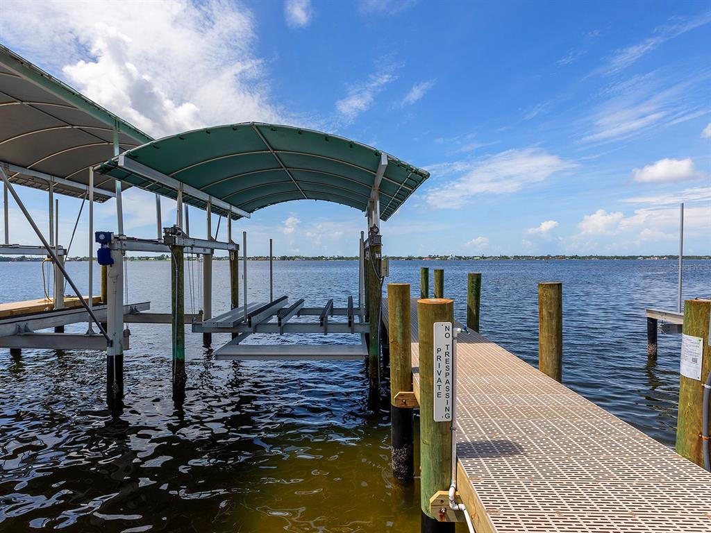 A boat lift with a green canopy sits beside a wooden dock over the water — 4024 11TH STREET COURT W, PALMETTO, FL