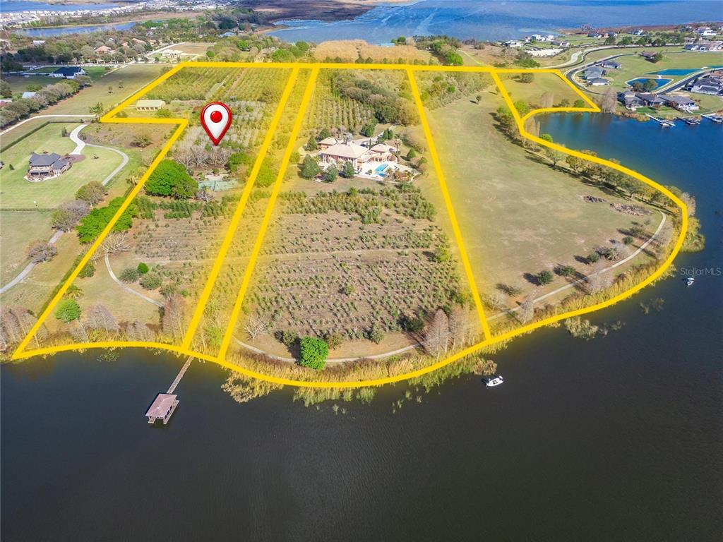 An aerial view shows a large waterfront property with orchards, trees, and a house — ADAMS BARN ROAD, AUBURNDALE, FL