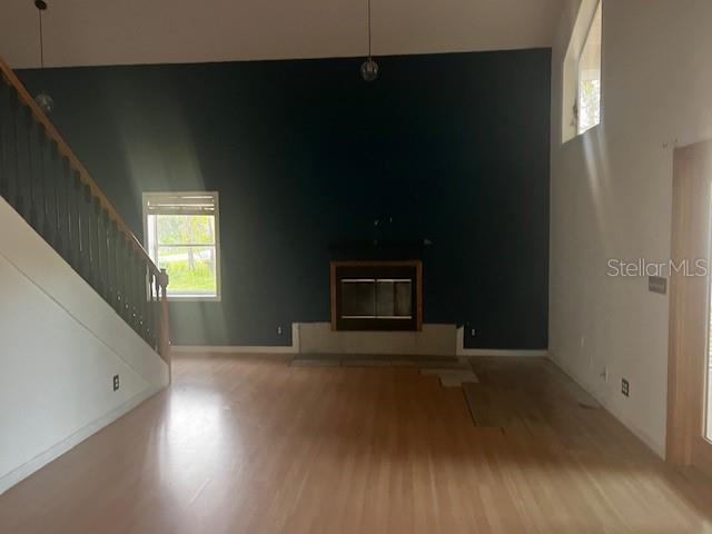 A living room features a dark accent wall, a fireplace, and a wooden staircase — 33 SEVEN WONDERS TRAIL, PALM COAST, FL