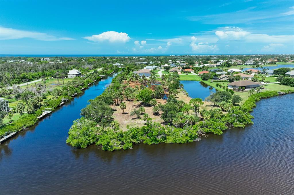 An aerial view shows a waterfront lot with palm trees surrounded by canals and homes — 4700 ARLINGTON DRIVE, PLACIDA, FL