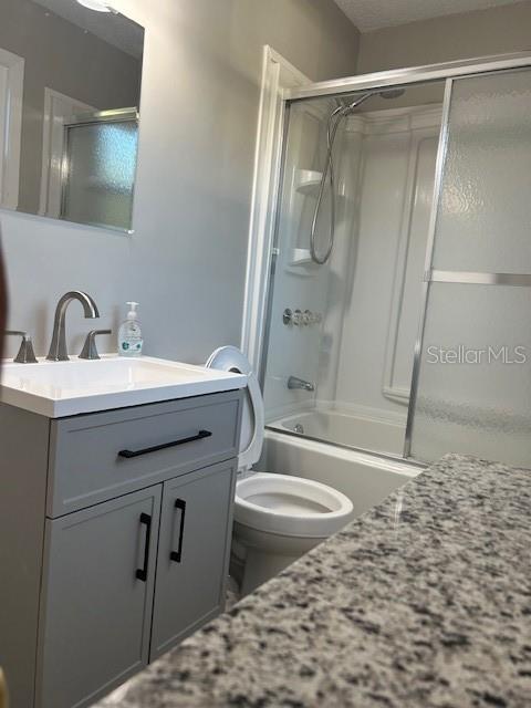 A bathroom features a gray vanity with a white sink, a toilet, and a shower-tub combo — 2750 N COMANCHE POINT, CRYSTAL RIVER, FL