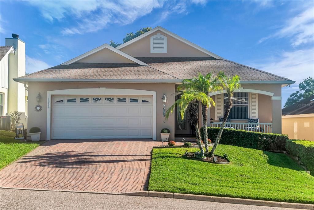 A single-story house with a brick driveway, a two-car garage, and a front porch — 1036 LINKSIDE COURT, APOPKA, FL