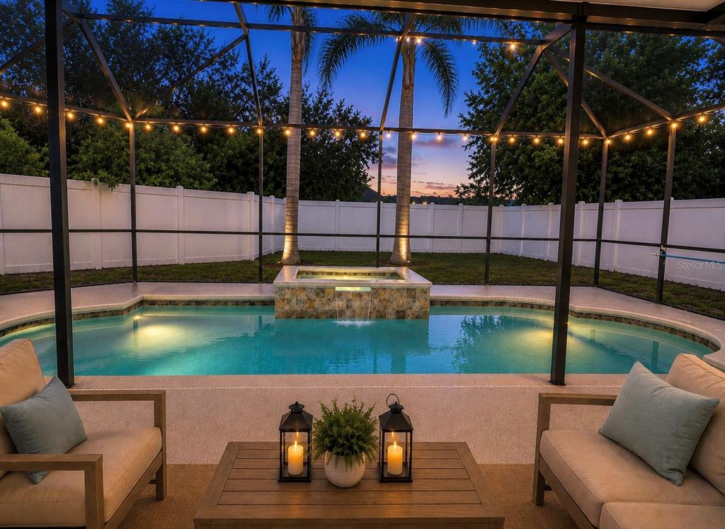 A screened-in patio features a swimming pool with an integrated hot tub and waterfall — 6801 CAMBRIDGE PARK DRIVE, APOLLO BEACH, FL