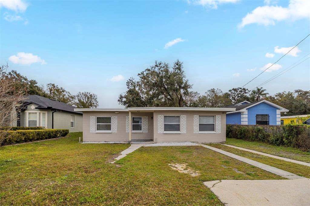 A single-story, light-colored house with a flat roof and a concrete driveway — 451 ROGERS STREET, ORLANDO, FL