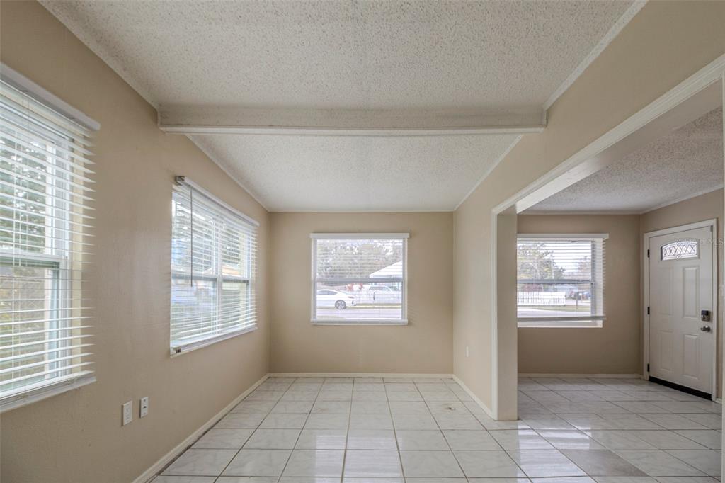 A bright room with white tile floors, beige walls, and multiple windows with blinds — 451 ROGERS STREET, ORLANDO, FL
