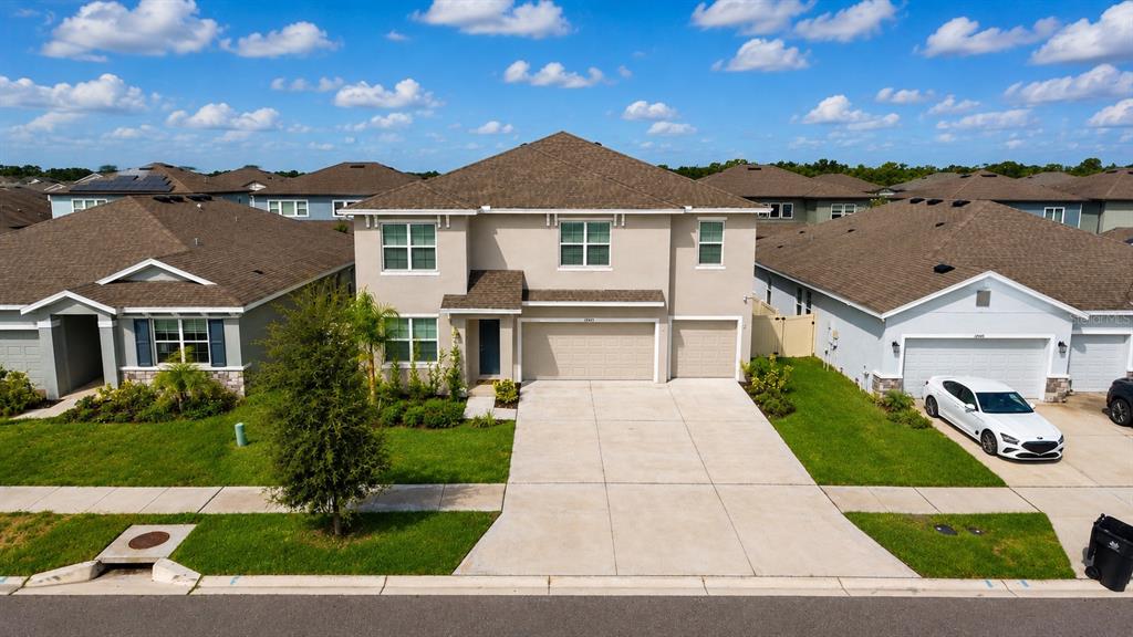 An exterior view of a two-story suburban house with a concrete driveway and attached garage — 12455 SHINING WILLOW STREET, RIVERVIEW, FL
