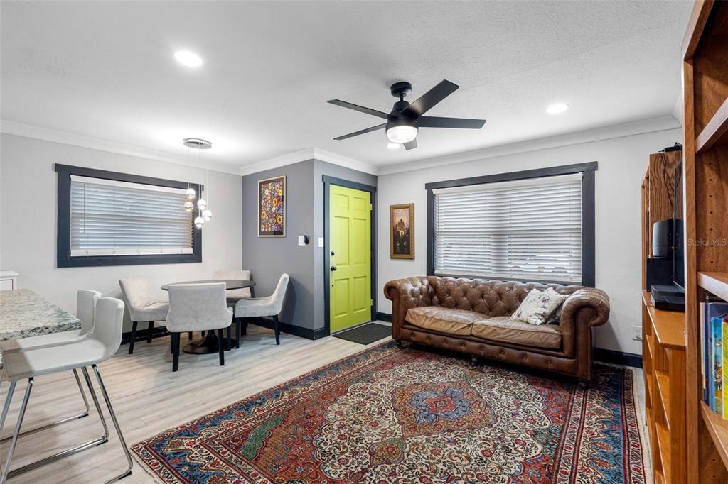 A living and dining area features a lime green door, leather sofa, and patterned rug — 6114 N 23RD STREET, TAMPA, FL