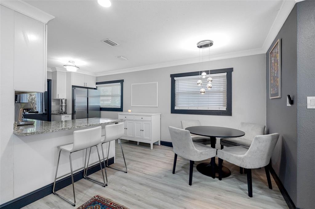A kitchen with a granite breakfast bar and an adjacent dining area with gray walls — 6114 N 23RD STREET, TAMPA, FL