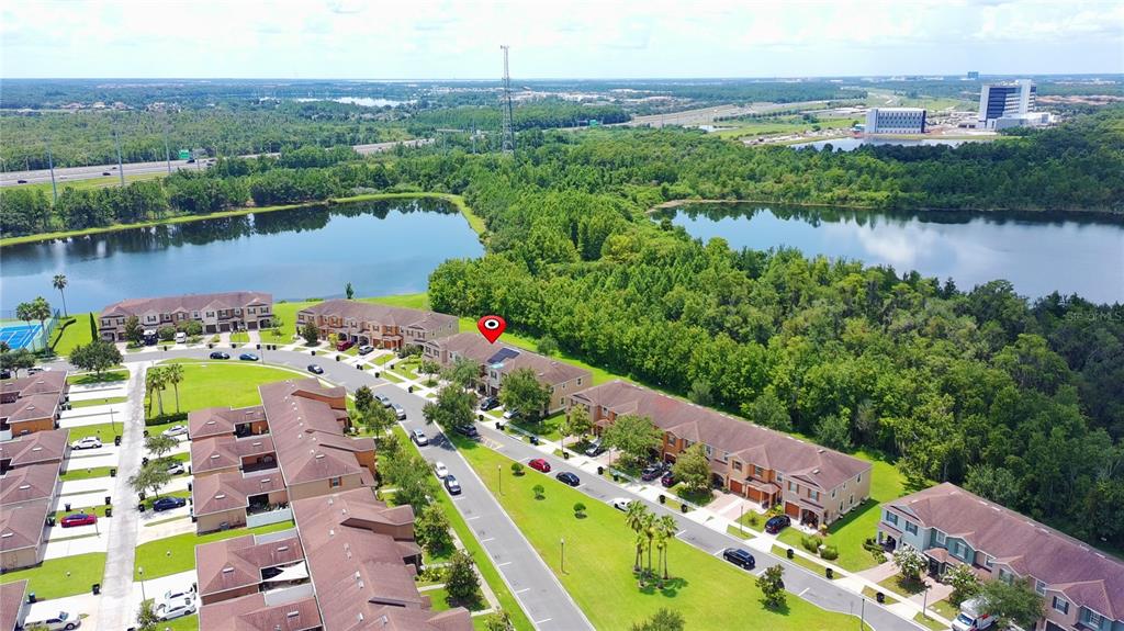 An aerial view shows a residential townhouse complex with a red location pin on a roof — 11155 SAVANNAH LANDING CIRCLE, ORLANDO, FL