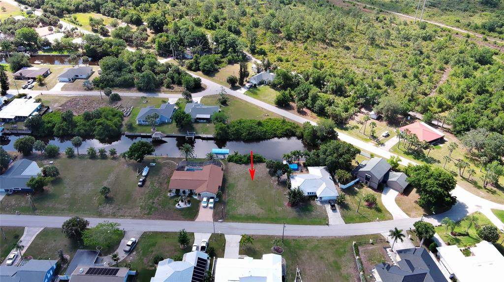 An aerial view shows a vacant waterfront lot situated between two houses on a street — 2060 RIVER BASIN TERRACE, PUNTA GORDA, FL